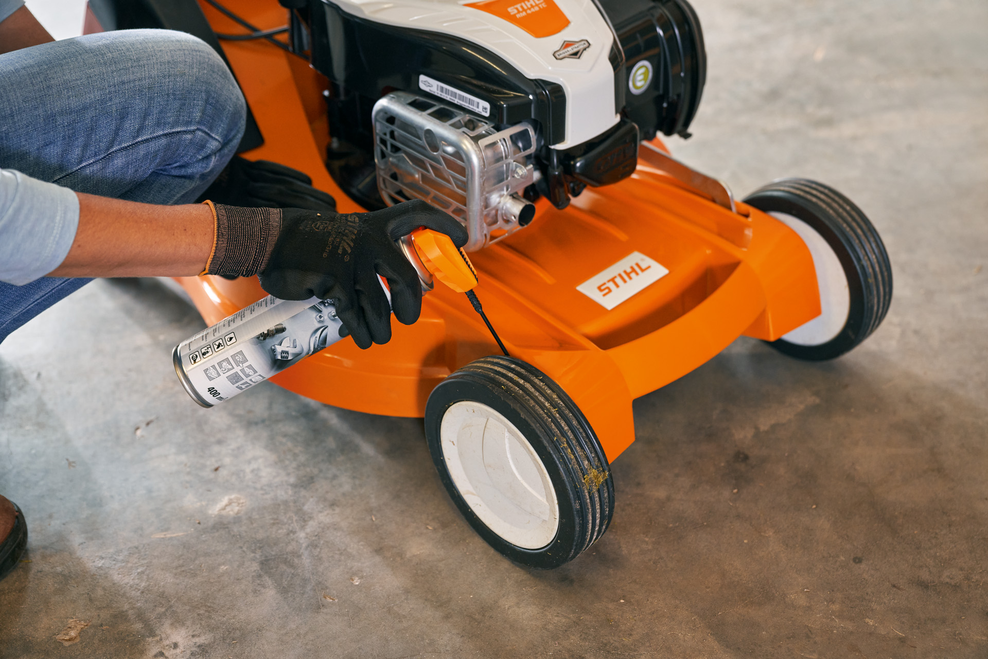 Kobieta przechowuje kosiarkę benzynową STIHL RM 448 TC w garażu 