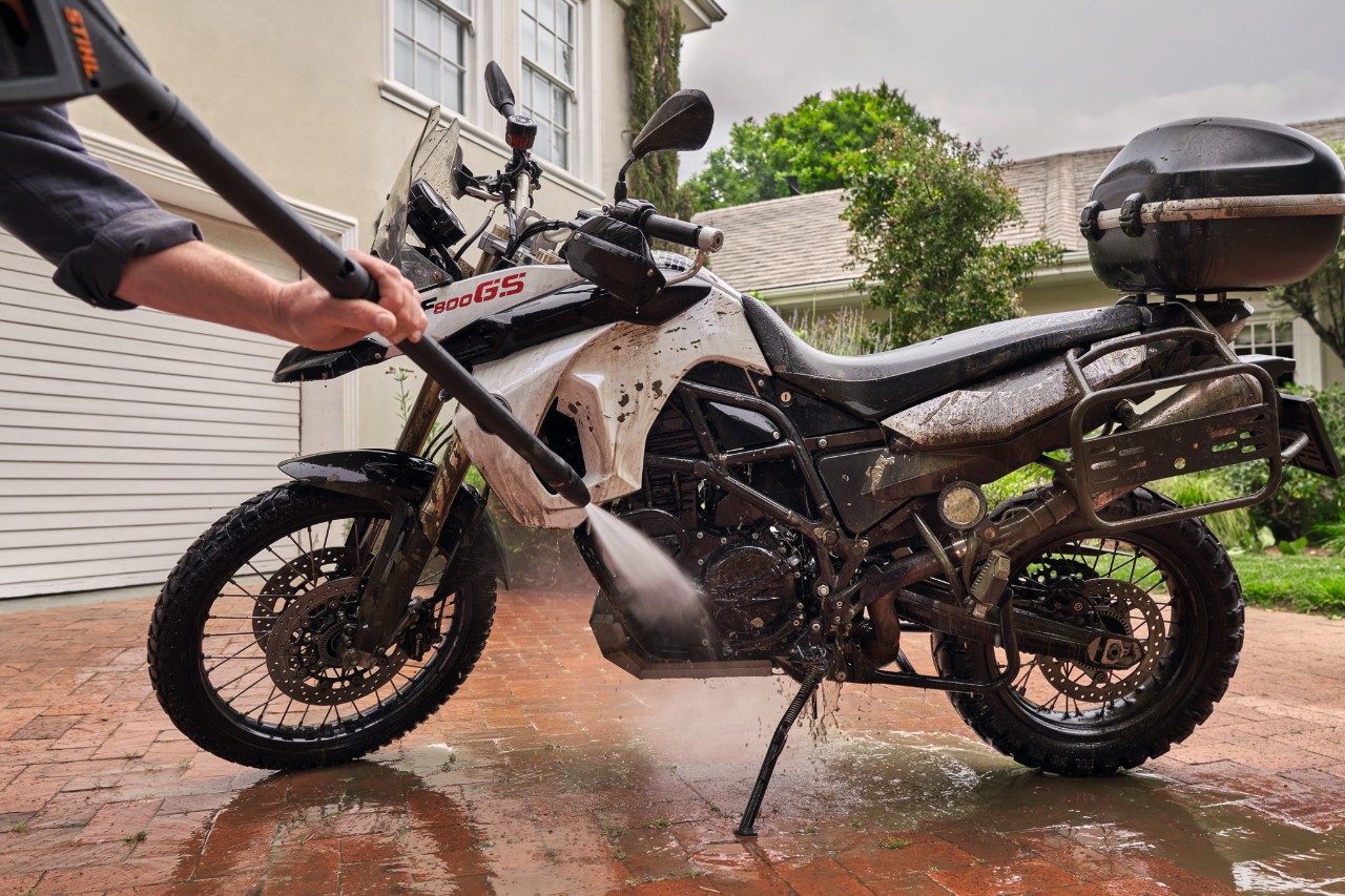 Czyszczenie motocykla przy białym domu za pomocą myjki wysokociśnieniowej STIHL RE 130 plus