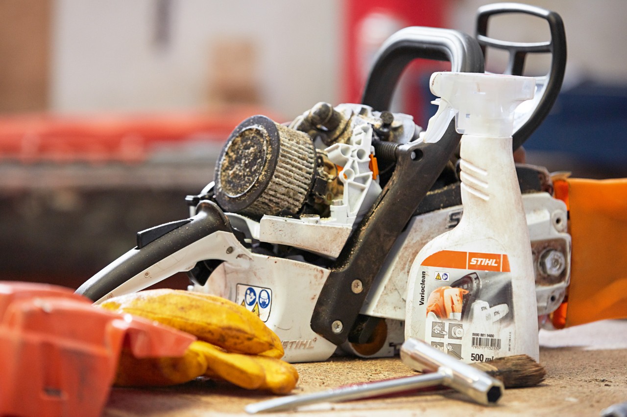 Środek czyszczący STIHL Varioclean obok pilarki łańcuchowej STIHL na stole warsztatowym
