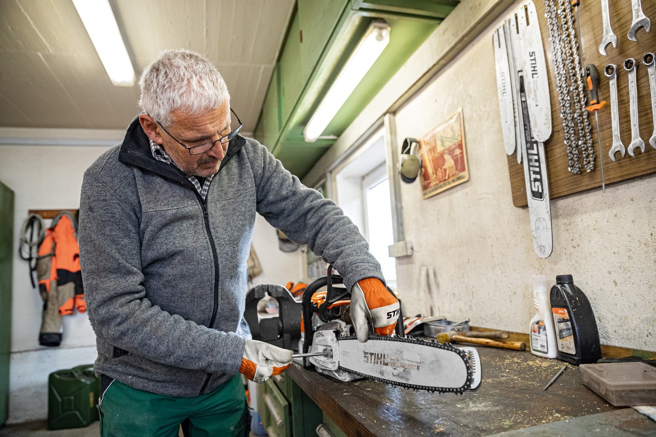 Mężczyzna napinający piłę łańcuchową STIHL