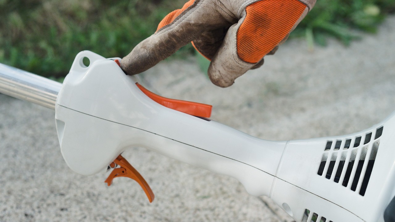 Na benzynowej kosie mechanicznej STIHL FS 38 naciskany jest przycisk zatrzymania