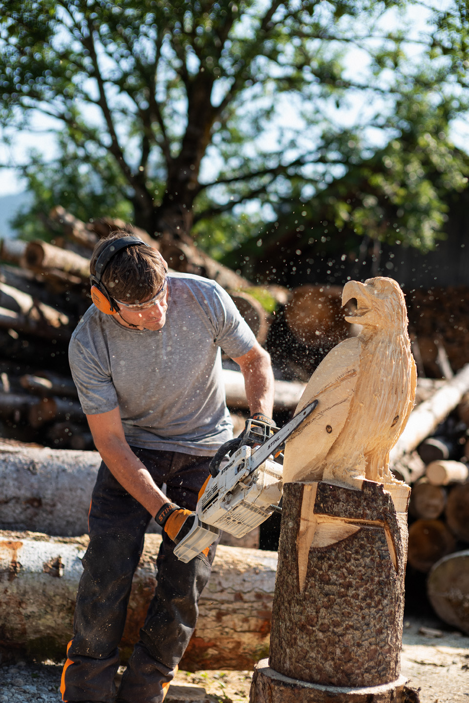 Mężczyzna rzeźbi drewnianego ptaka pilarką łańcuchową STIHL 