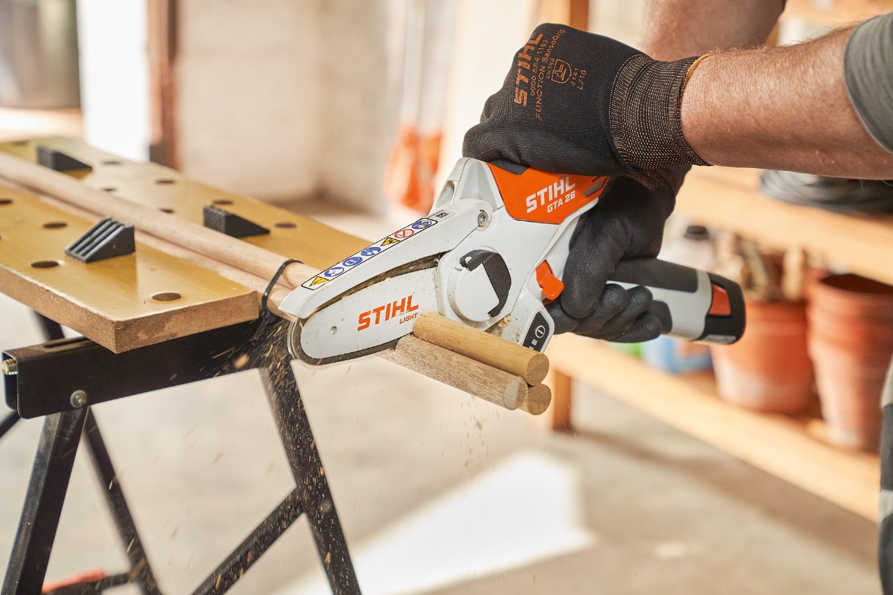 Mężczyzna piłuje pręty okrągłe za pomocą akumulatorowej przecinarki do drzew STIHL GTA 26