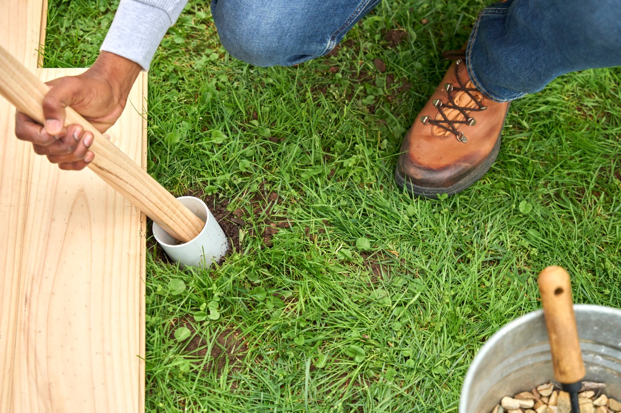Rozpórki namiotu są wkładane do plastikowej tuby wypełnionej piaskiem.