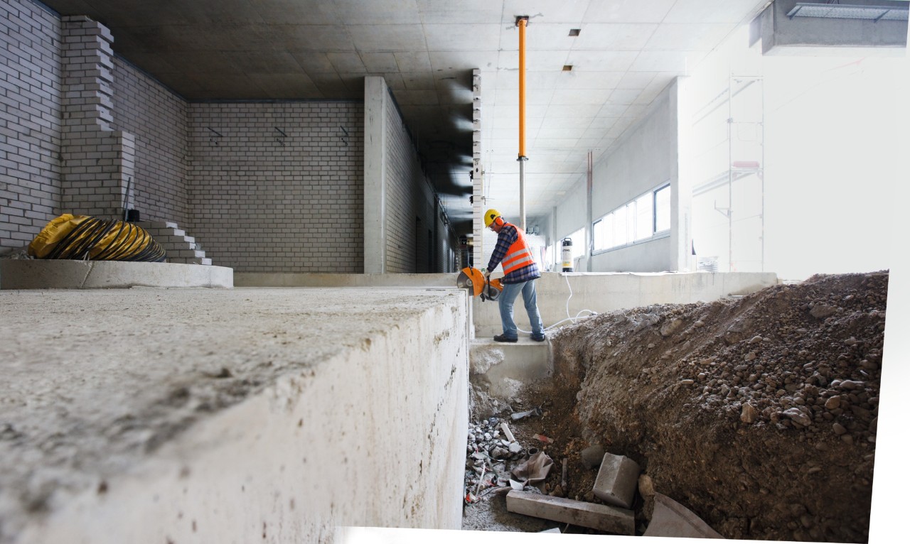 Mężczyzna z przecinarką spalinową STIHL TS 500i przecina stalowy sworzeń na placu budowy