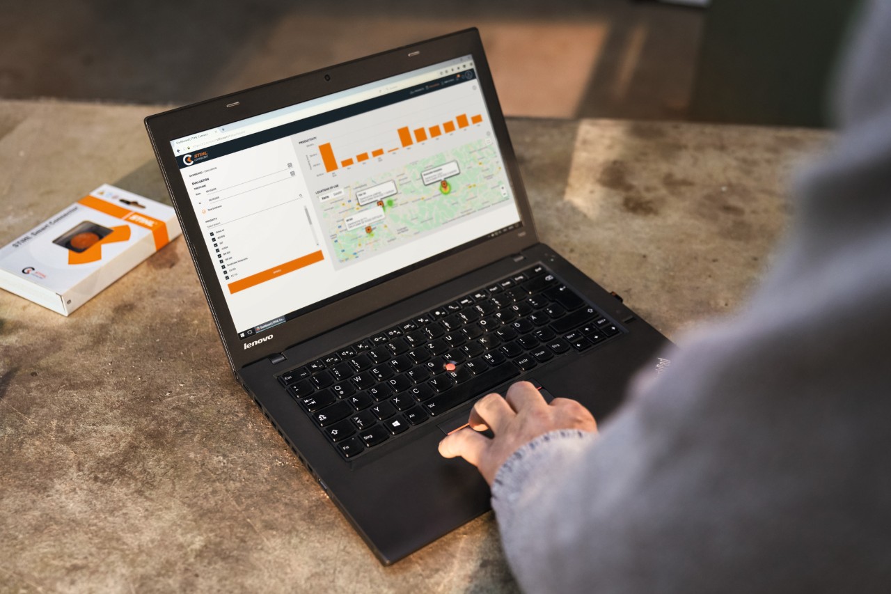 Osoba pracująca na laptopie pobiera istotne dane systemowe za pomocą STIHL connected 