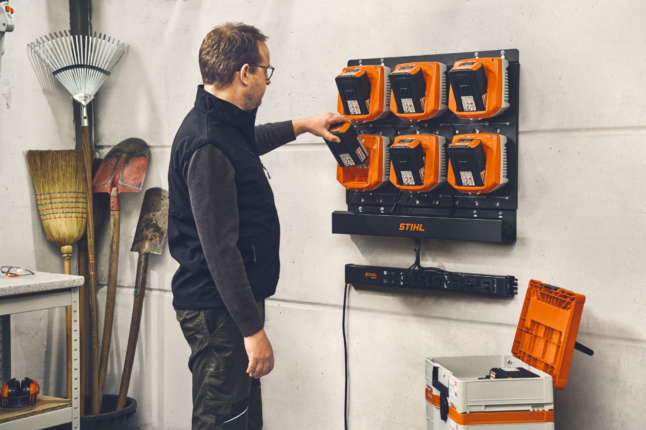 Naścienny system zarządzania ładowaniem STIHL CM 10, uchwyt ścienny STIHL CR 6 i ładowarka STIHL AL 301 w użyciu.