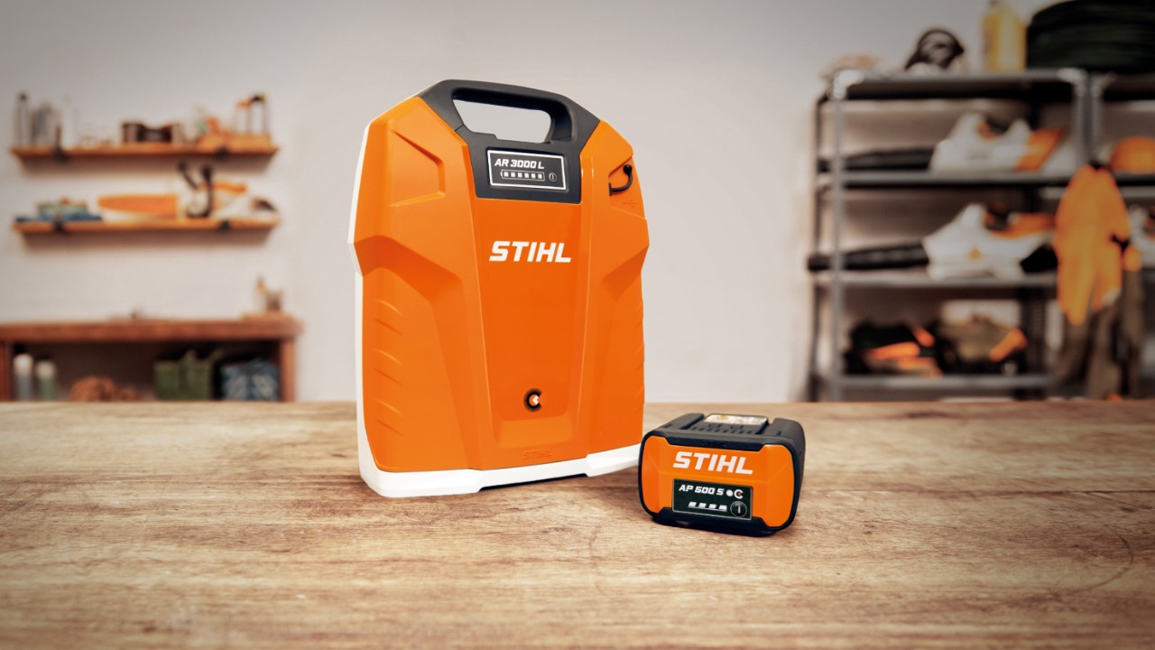 Warsztat z akumulatorem plecakowym STIHL AR 3000 L i akumulatorem STIHL AP 500 S na drewnianym stole  